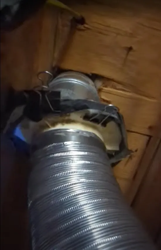 A dryer vent held together with binder clips, before repair