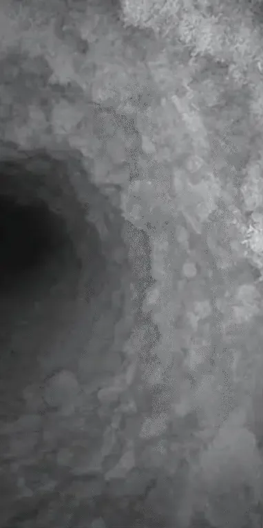 A dryer vent before cleaning, packed with lint