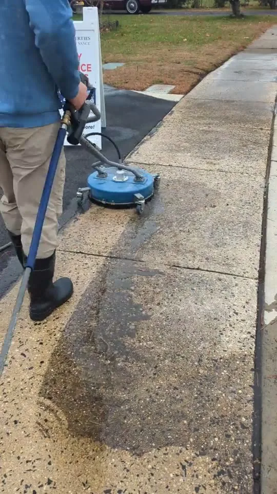 A concrete walkway being power washed